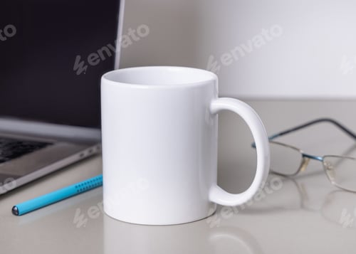 Preview: White coffee mug on grey office table against laptop, glasses and pencil closeup, mockup