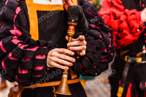 Preview: Medieval troubadour playing an old flute with other musicians in disguise.