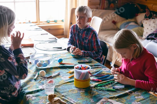 Preview: Children engaged in creative arts and crafts at a cozy home setting.