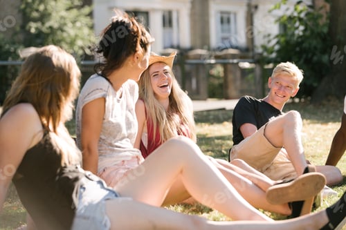 Preview: Young man and female friends chatting in park