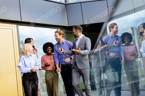 Preview: Diverse team of professionals discussing strategy outside modern office building at dusk