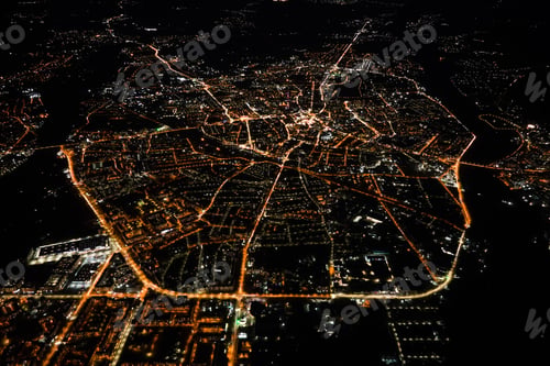 Preview: Aerial view from airplane window of buildings and bright illuminated streets in city