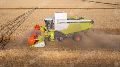 Preview: Aerial shot of harvester machinery collecting wheat grain in hot season in rural cultivated fields