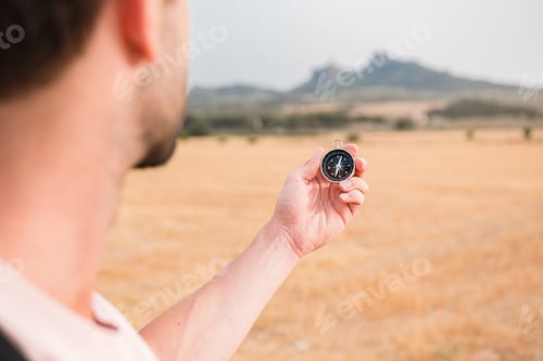 Preview: Man with a compass in a mountainous landscape