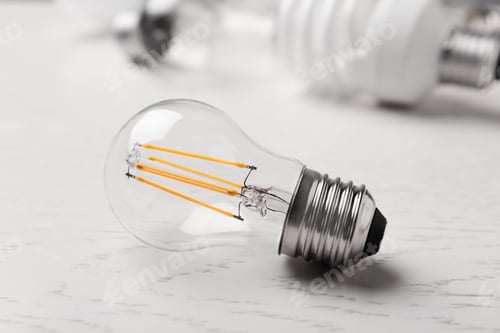 Preview: Vintage filament lamp bulb on white wooden table