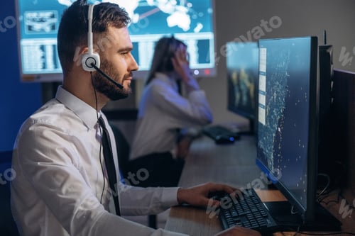 Preview: In headphones. People are working by computers in airline company