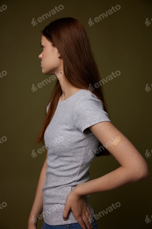 Preview: woman in gray t-shirt hand with adhesive plaster vaccination health immunity