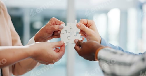 Preview: Hands, business people and puzzle with teamwork, cooperation and synergy in modern office. Closeup,