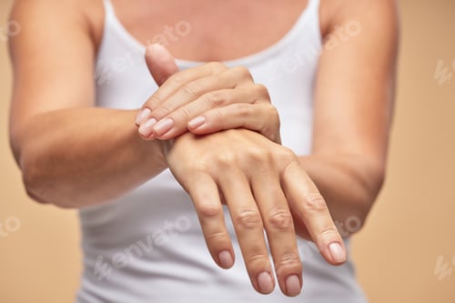 Preview: Woman in white t-shirt using hand skin care product