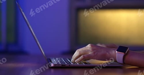Preview: Woman type on computer at night