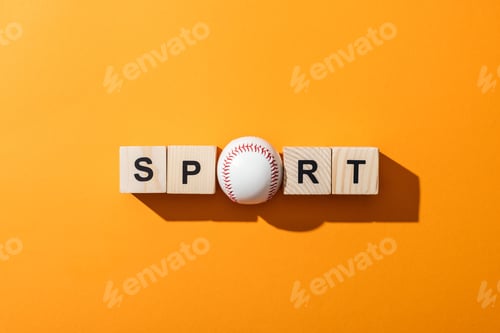 Preview: top view of softball near wooden cubes with sport lettering on yellow