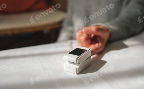 Preview: A woman using digital fingertip pulse oximeter device to measure oxygen and blood pulse rate