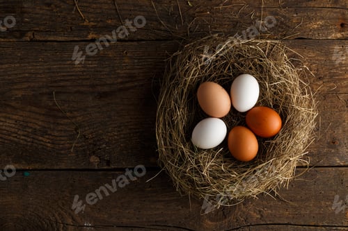 Preview: Chicken eggs in a nest on a wooden rustic background