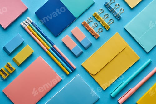 Preview: top view of notebooks and arranged colorful stationery isolated on blue