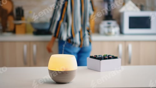 Preview: Woman in the kitchen with essential oils diffuser