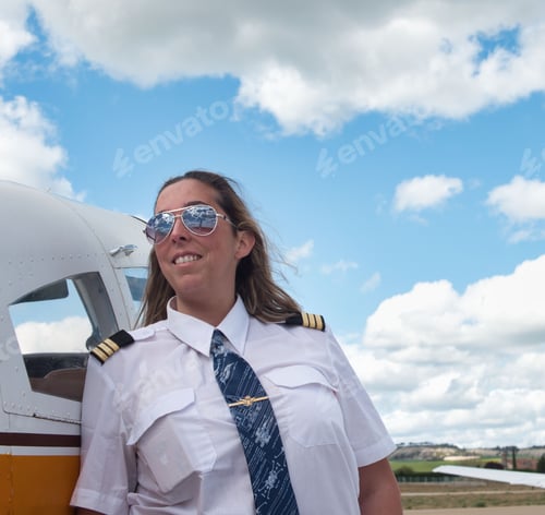 Preview: Caucasian female pilot posing near her airplane.