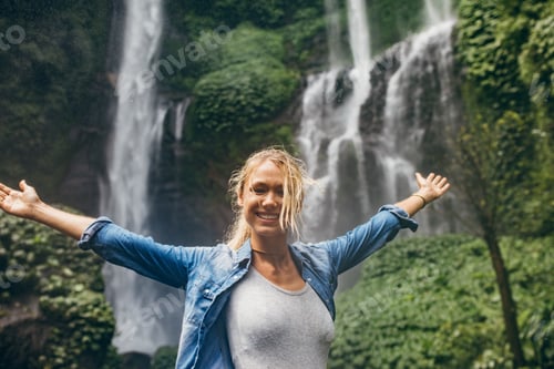 Preview: Tourist with tropical waterfall in background