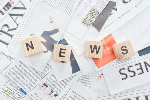 Preview: elevated view of wooden cubes with word news on newspapers