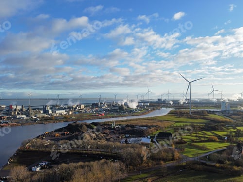 Preview: Aerial shot of an industrial center with windmills and buildings and a canal flowing along it