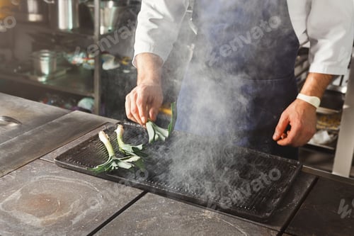 Preview: Chef cooking juicy beef steak at restaurant kitchen