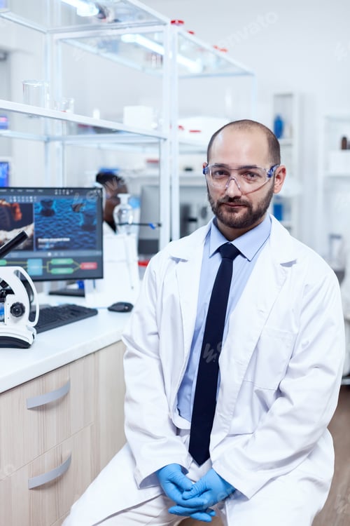 Preview: Healthcare researcher wearing lab coat and protective glasses