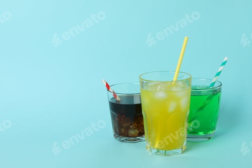 Preview: Glasses of different soda on blue background