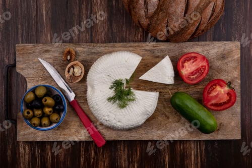 Preview: top view feta cheese with cucumber tomatoes olives and a knife on a stand