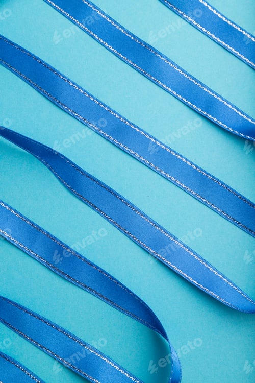 Preview: Blue ribbon on a blue pastel background. Top view.