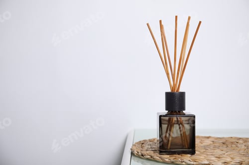 Preview: Aromatic reed freshener on table near white wall, space for text