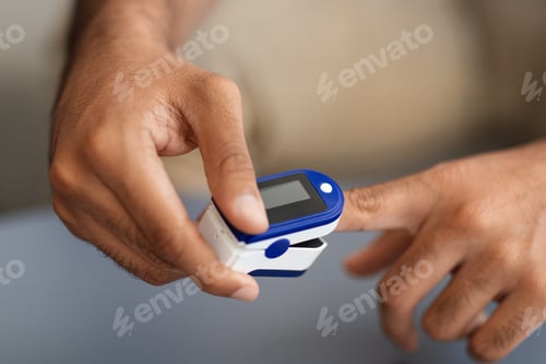Preview: Male hands using pulse oximeter, closeup photo
