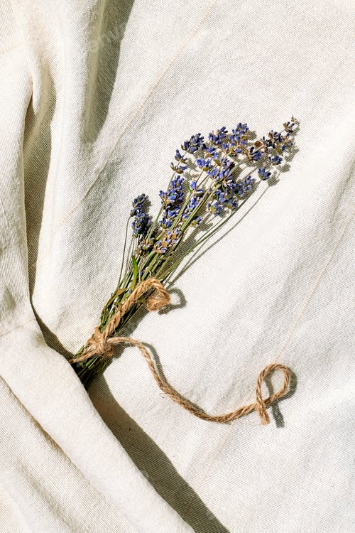 Preview: Sprigs of violet lavender flowers on linen fabric. Dry flower floral composition in pastel colors.