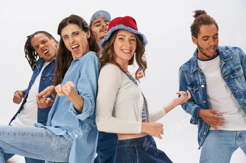 Preview: joyful multicultural friends in trendy casual wear having fun and dancing on grey backdrop