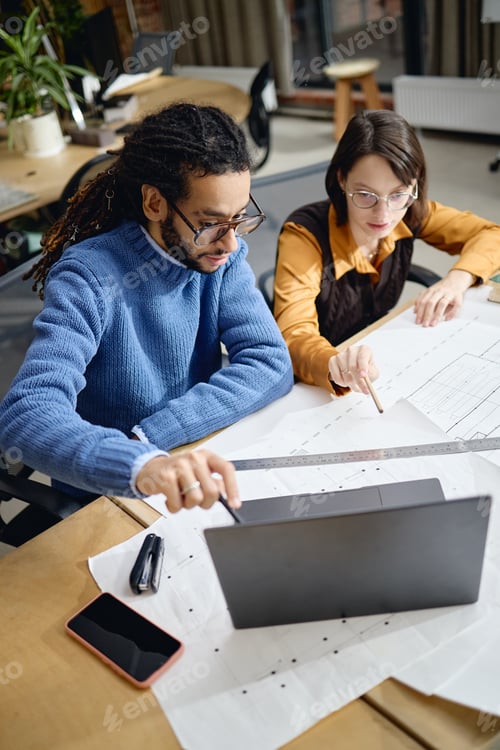 Preview: Young Caucasian Woman and Young Black Man Collaborating on Architectural Project