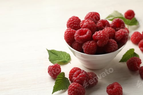Preview: Tasty fresh ripe raspberries and leaves on white wooden table, closeup. Space for text