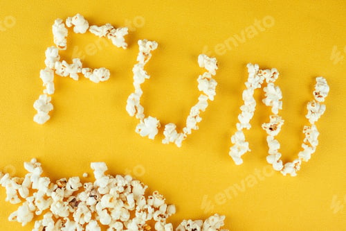 Preview: popcorn scattered on yellow background inscription fun.