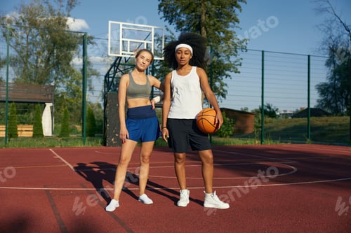 Preview: Beautiful young sports women basketball player on outdoor court