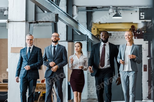 Preview: multicultural group of handsome businessmen and attractive businesswomen walking in office