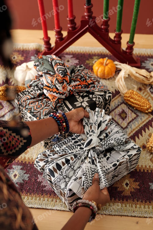 Preview: Woman tying knot on top of packed gift