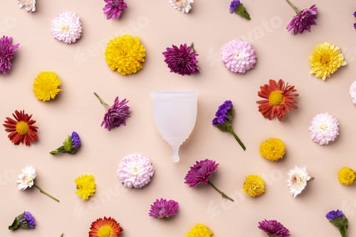 Preview: Menstrual cup on floral pattern background top view