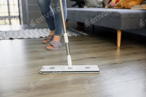 Preview: Woman mopping, wiping floor in modern home setting