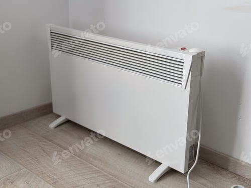 Preview: Modern white electric heater placed against a plain wall. Functional design and a minimalist