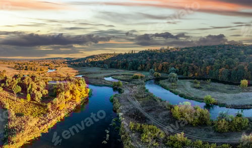 Preview: Road stretching between meadows and rivers under blue sky