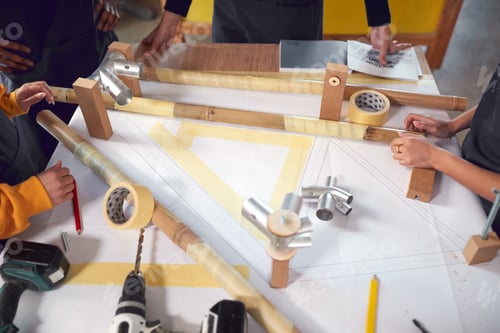 Preview: Close Up Of Multi-Cultural Team In Workshop Assembling Hand Built Bamboo Bicycle Frame