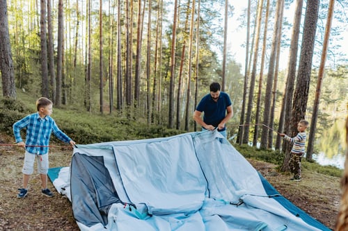 Preview: children helping father to put up a tent. Family camping concept