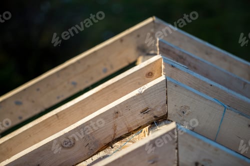 Preview: Close-up detail of roof frame of rough wooden lumber beams on background