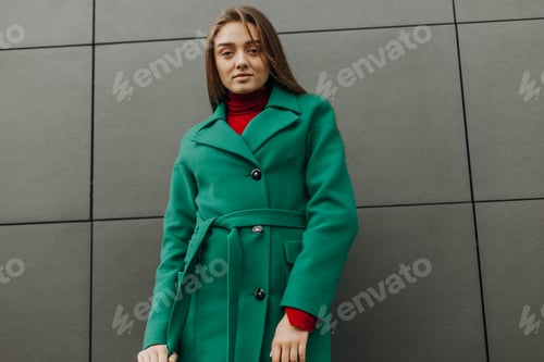 Preview: Beautiful fashion model in autumn green clothes on background. Sexy lady in elegant coat.