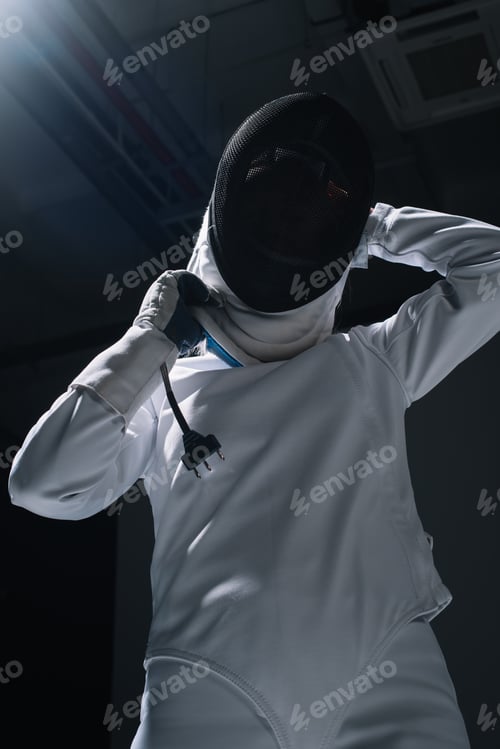 Preview: Low angle view of fencer putting on fencing mask