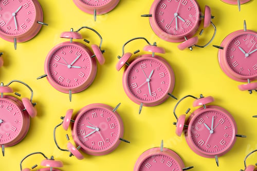 Preview: Creative layout of pink alarm clock's on pastel yellow background. Minimal concept.