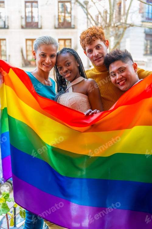 Preview: Cheerful and diverse friends standing together proudly holding a colorful LGBT flag