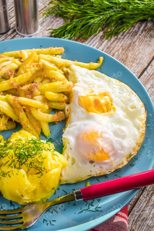 Preview: Fried egg served with boiled potatoes and yellow beans.